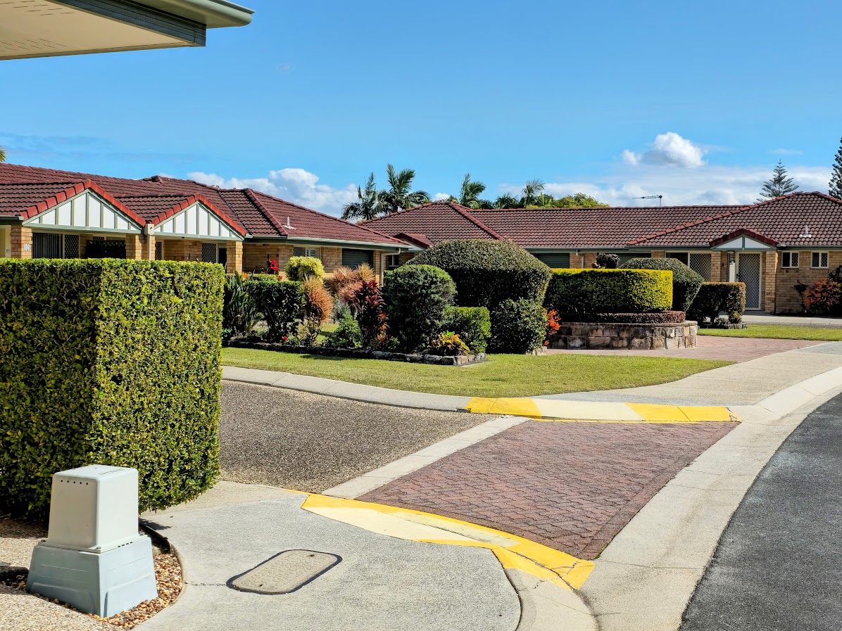Clipped hedges lining paths between retirement village homes